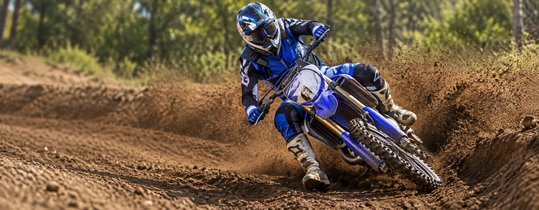 Pilota di motocross con protezioni su una pista sterrata