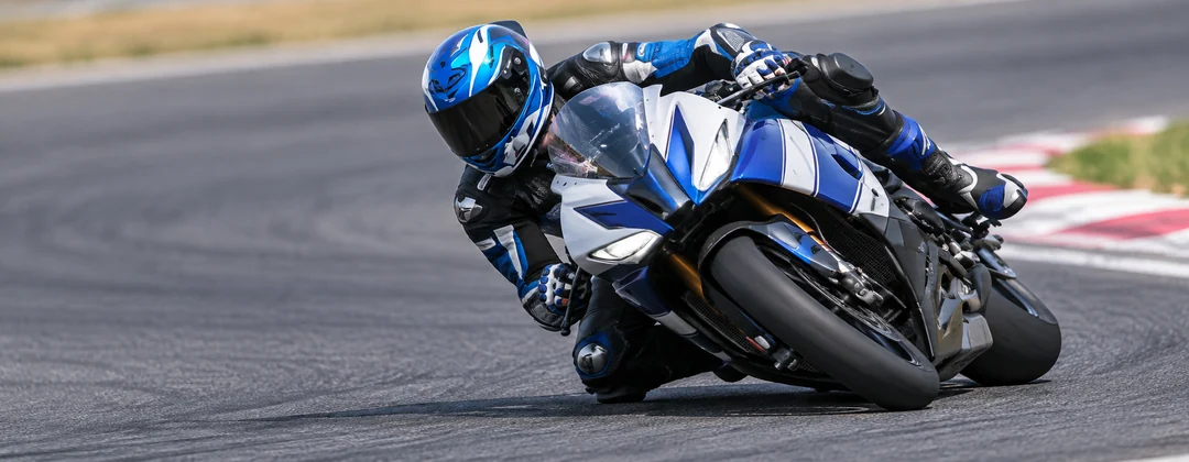 Pilota con tuta e casco su una moto sportiva in pista