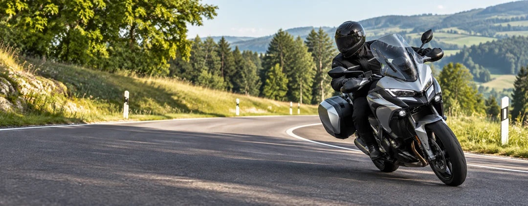 Motociclista con moto touring su una strada di campagna